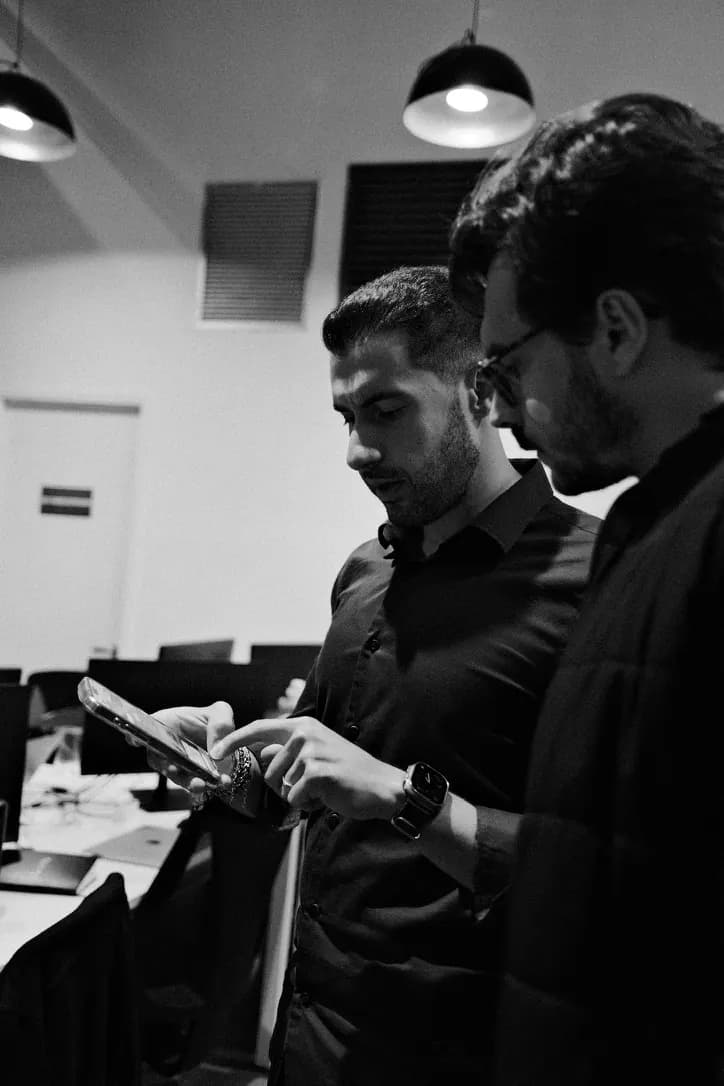Duas pessoas do time olham juntas para a tela de um celular